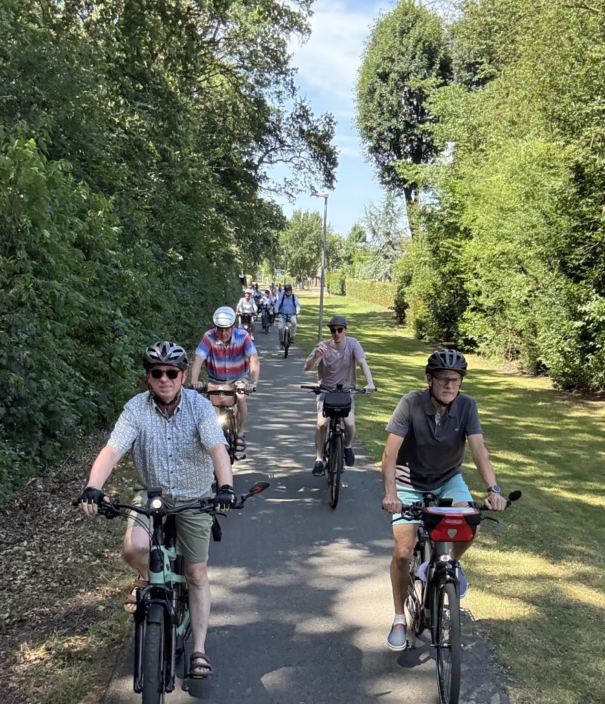 Radfahrer hintereinander auf einem schattigen Radweg